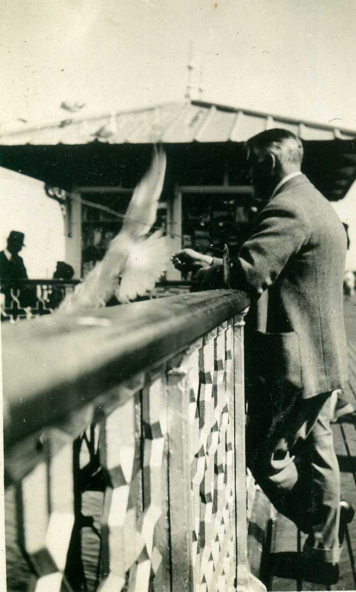 Vintage Black & White Photograph - A smartly dressed man on pier, seagull flying